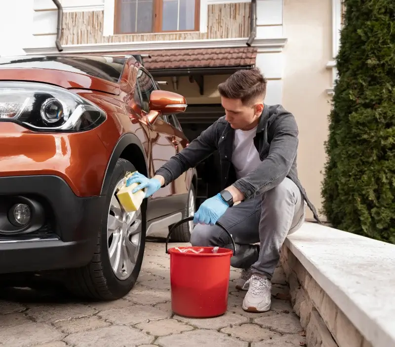 Lavage auto à domicile Condé-sur-Vesgre : professionnel intervenant sur un véhicule